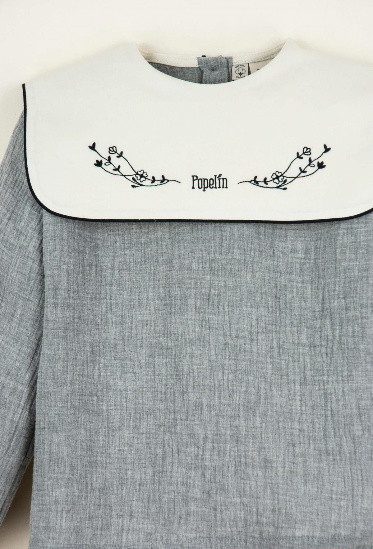 Mod.12.4 Light grey embroidered organic fabric blouse with bib | AW22.23 Mod.12.4 Light grey embroidered organic fabric blouse with bib